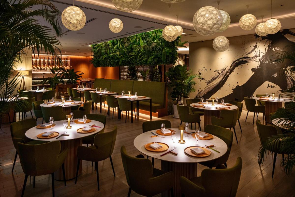 a restaurant with tables and chairs and chandeliers at Capri by Fraser China Square, Singapore in Singapore a restaurant with tables and chairs and chandeliers at Capri by Fraser China Square, Singapore in Singapore