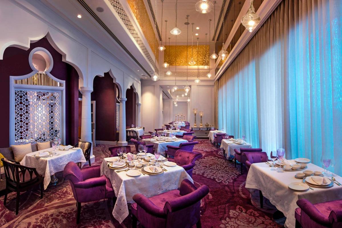 a dining room with tables and purple chairs at ITC Kohenur, a Luxury Collection Hotel, Hyderabad in Hyderabad