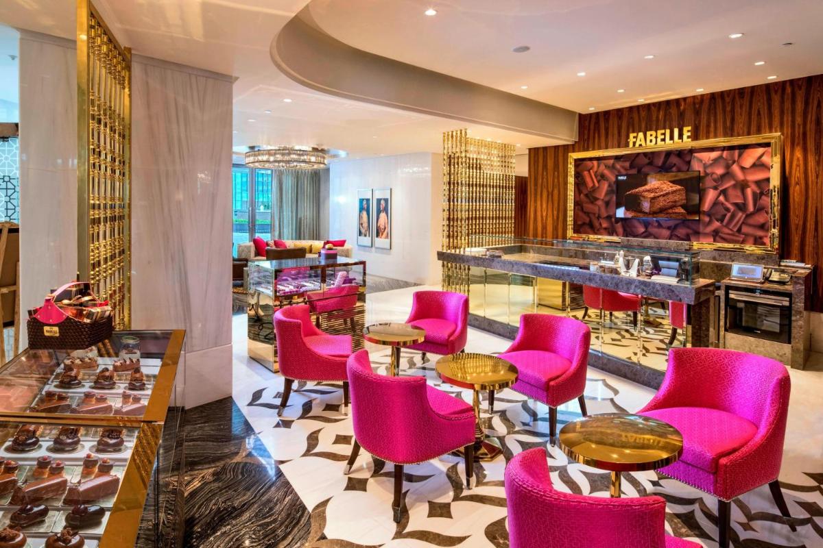 a hotel lobby with pink chairs and a bar at ITC Kohenur, a Luxury Collection Hotel, Hyderabad in Hyderabad