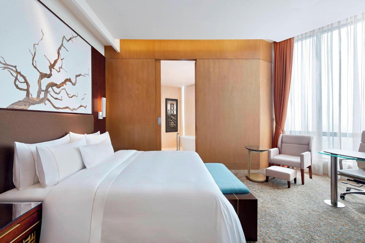 a hotel room with a large bed and a desk at The Westin Kolkata Rajarhat in Kolkata a hotel room with a large bed and a desk at The Westin Kolkata Rajarhat in Kolkata