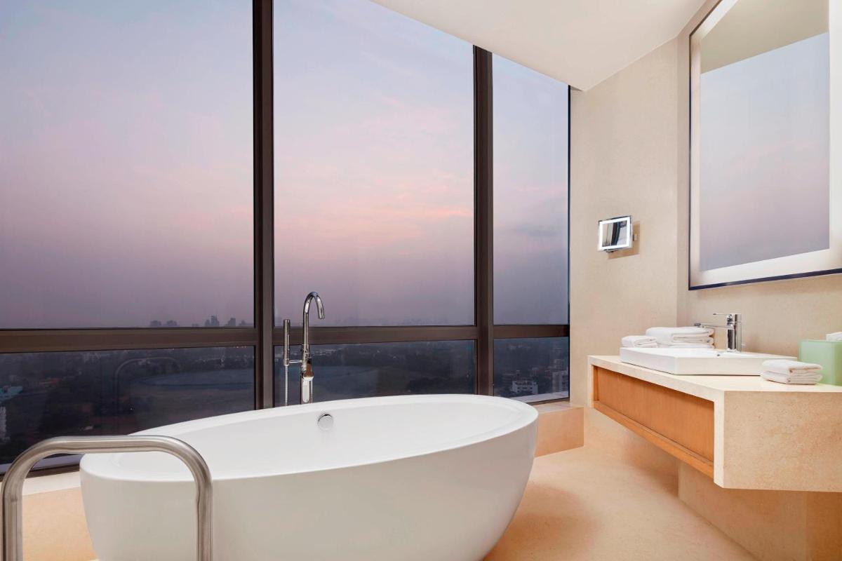 a bathroom with a large tub and a large window at The Westin Kolkata Rajarhat in Kolkata a bathroom with a large tub and a large window at The Westin Kolkata Rajarhat in Kolkata