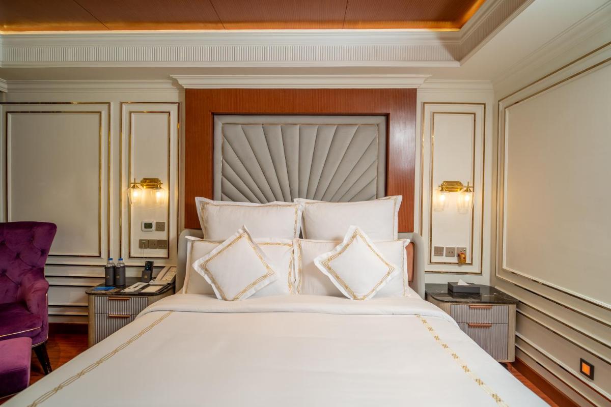 a bedroom with a large bed with white pillows at The Accord Metropolitan in Chennai