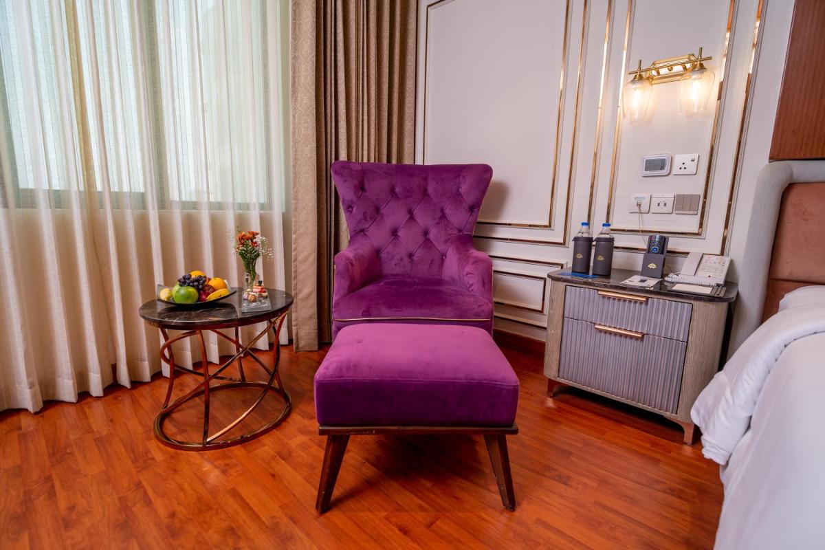 a purple chair and a table in a hotel room at The Accord Metropolitan in Chennai
