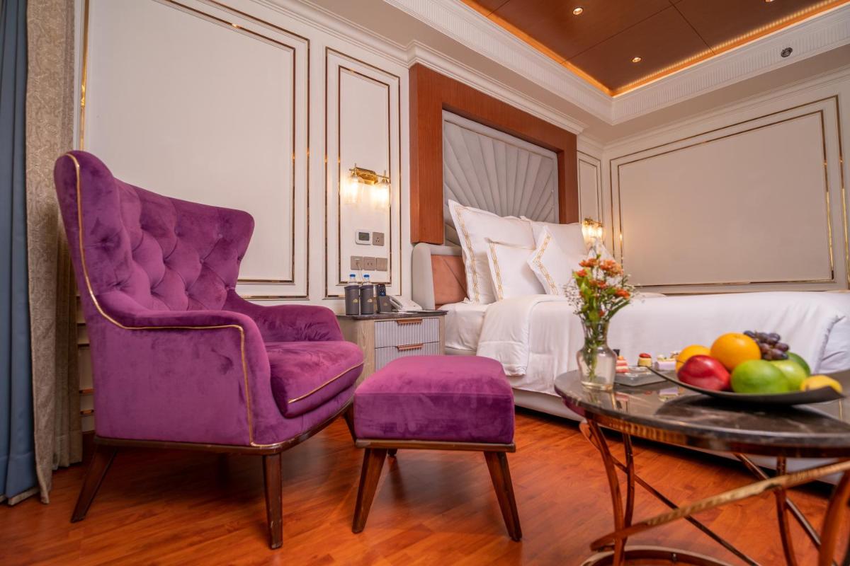 a bedroom with a purple chair and a table and a bed at The Accord Metropolitan in Chennai