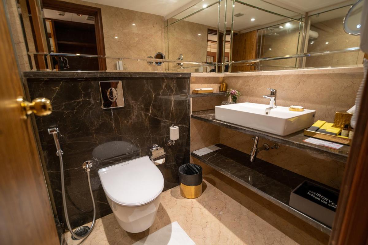 a bathroom with a white toilet and a sink at The Accord Metropolitan in Chennai