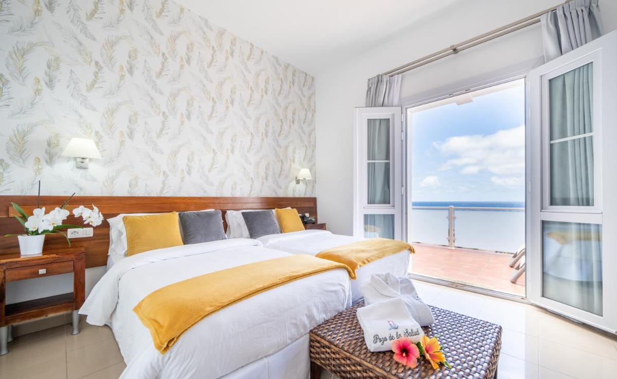 Un dormitorio con una cama grande y una ventana grande. en Balneario Pozo de la Salud, en Sabinosa