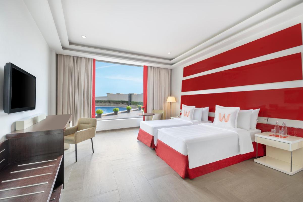 a hotel room with two beds and a television at Welcomhotel by ITC Hotels, Dwarka, New Delhi in New Delhi a hotel room with two beds and a television at Welcomhotel by ITC Hotels, Dwarka, New Delhi in New Delhi