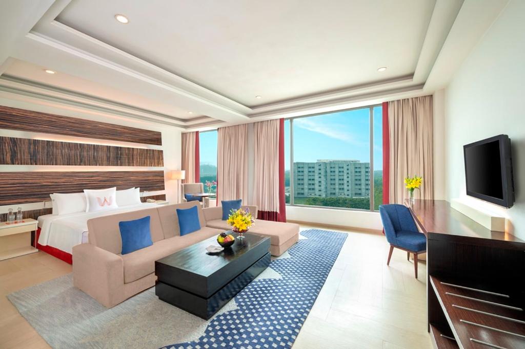 a large hotel room with a bed and a tv at Welcomhotel by ITC Hotels, Dwarka, New Delhi in New Delhi a large hotel room with a bed and a tv at Welcomhotel by ITC Hotels, Dwarka, New Delhi in New Delhi