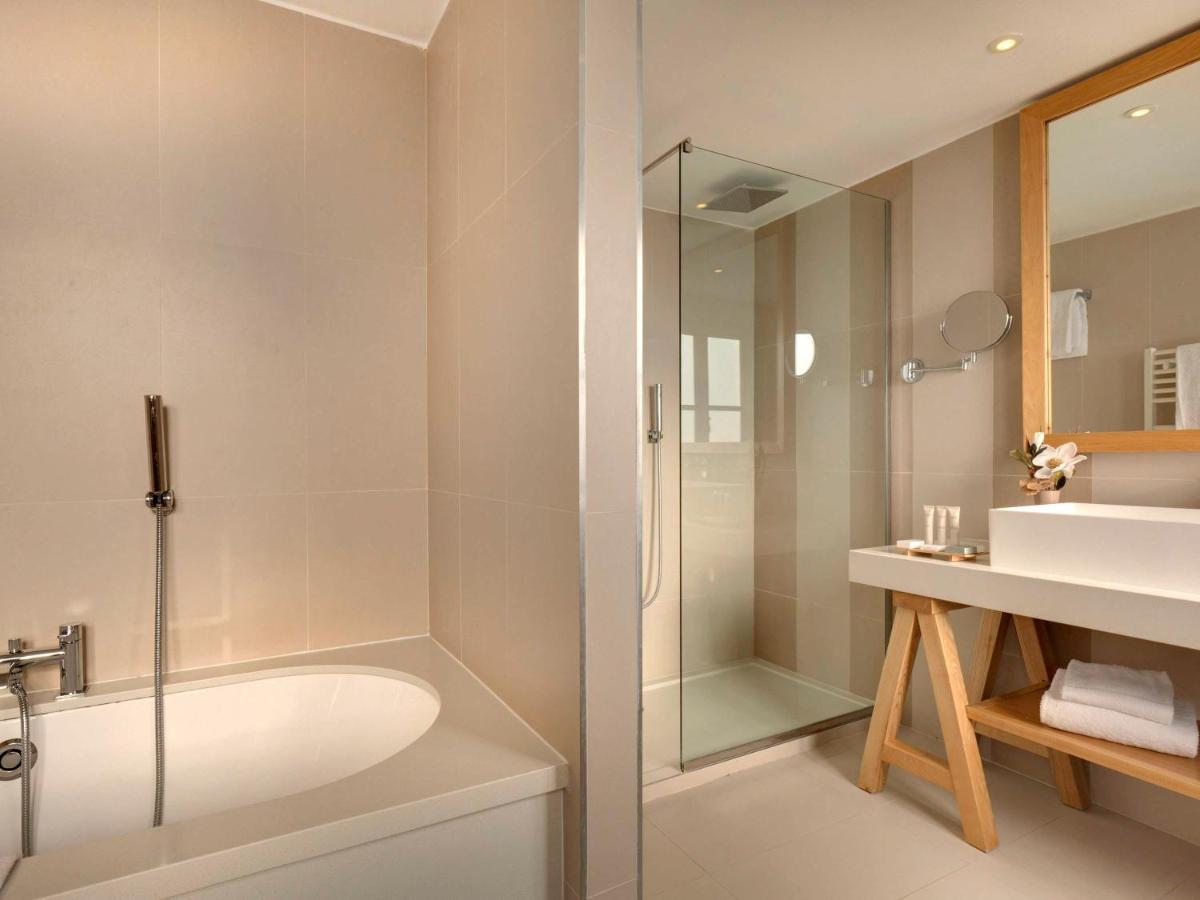 une salle de bain avec douche, baignoire et lavabo dans l'établissement Mercure Maintenon, à Maintenon