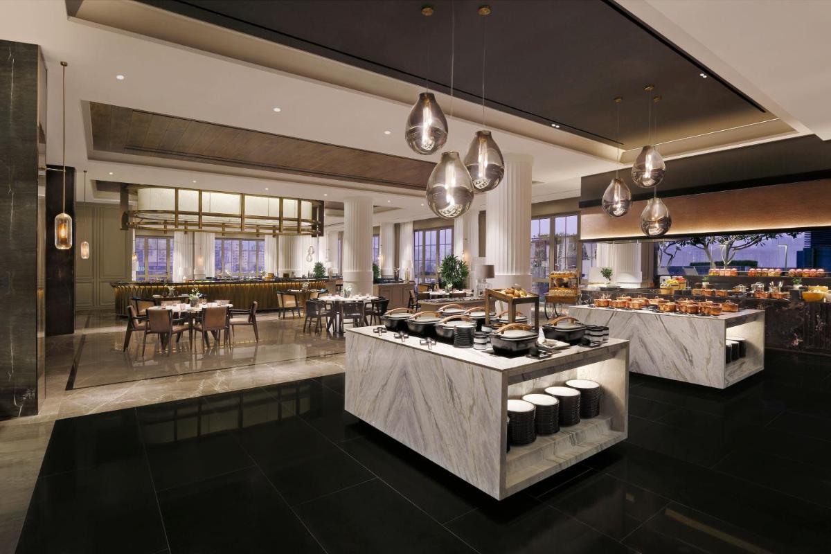 a restaurant with a buffet with a table of food at The Westin Pune Koregaon Park in Pune