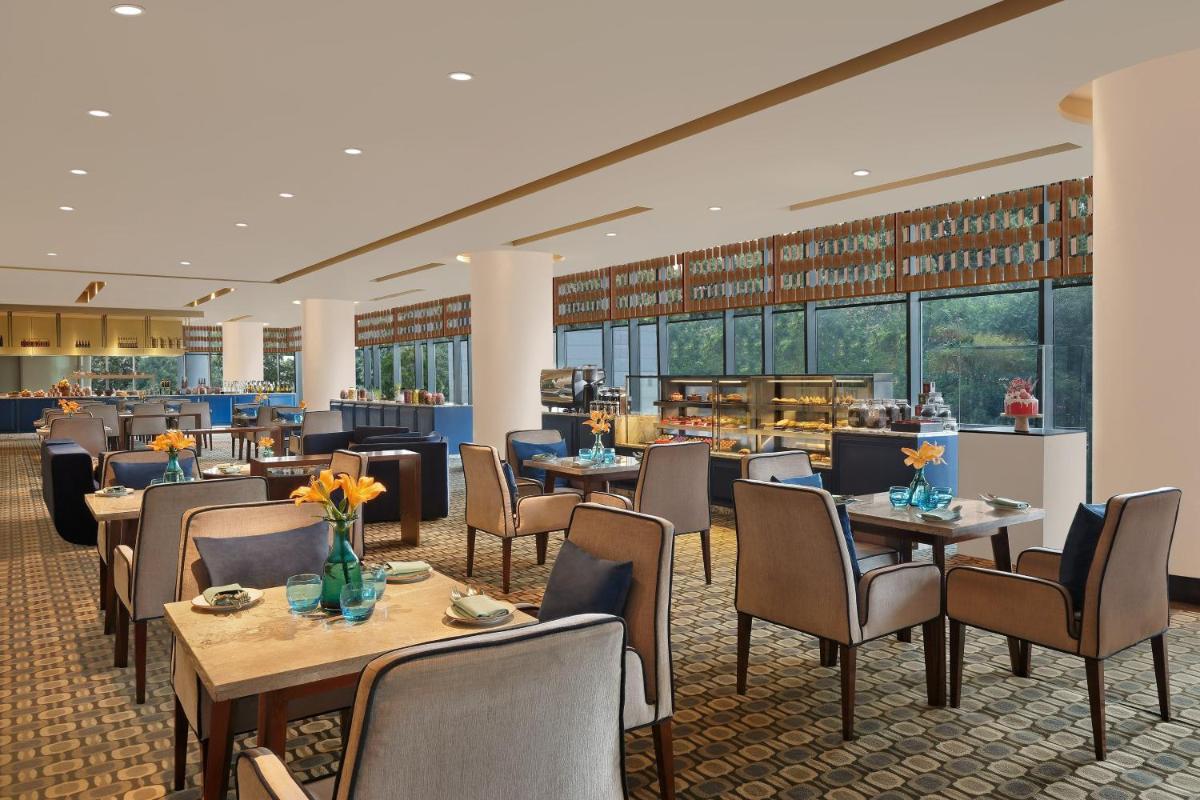 a restaurant with tables and chairs and a cafeteria at The Westin Pune Koregaon Park in Pune