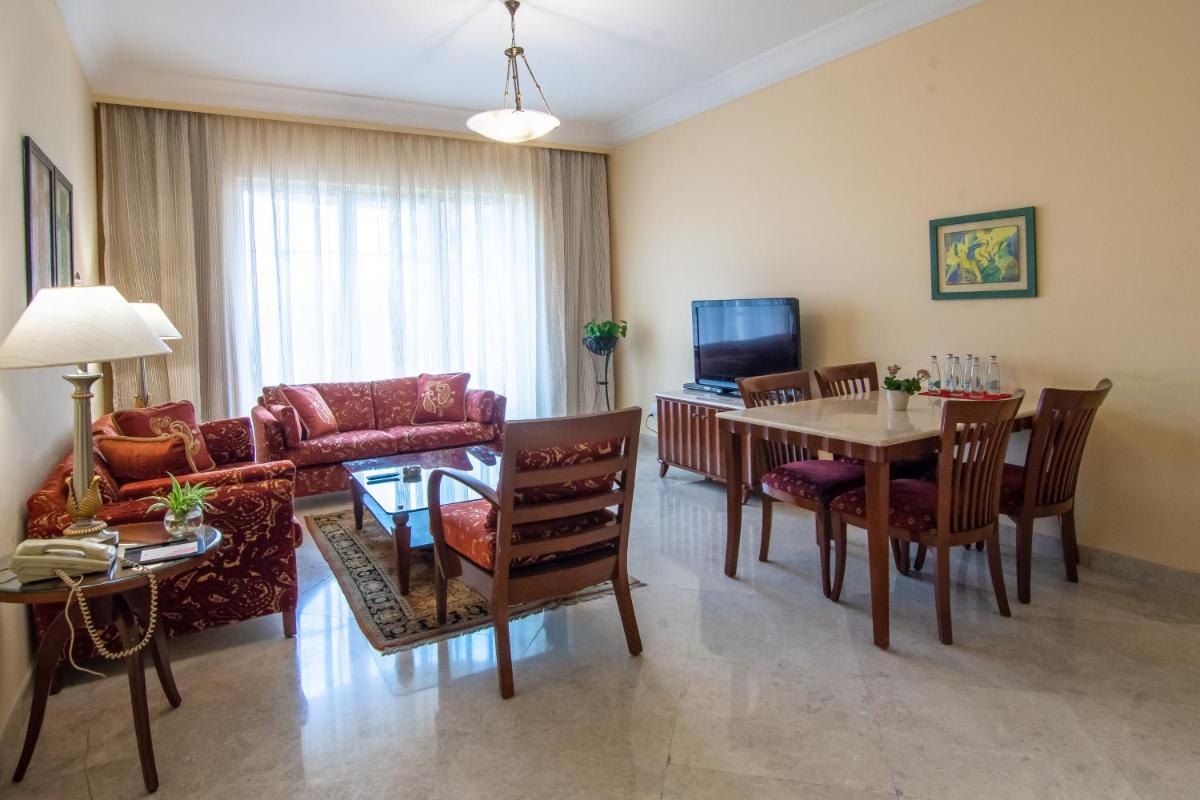 a living room with a couch and a table and chairs at The Lalit Mumbai in Mumbai