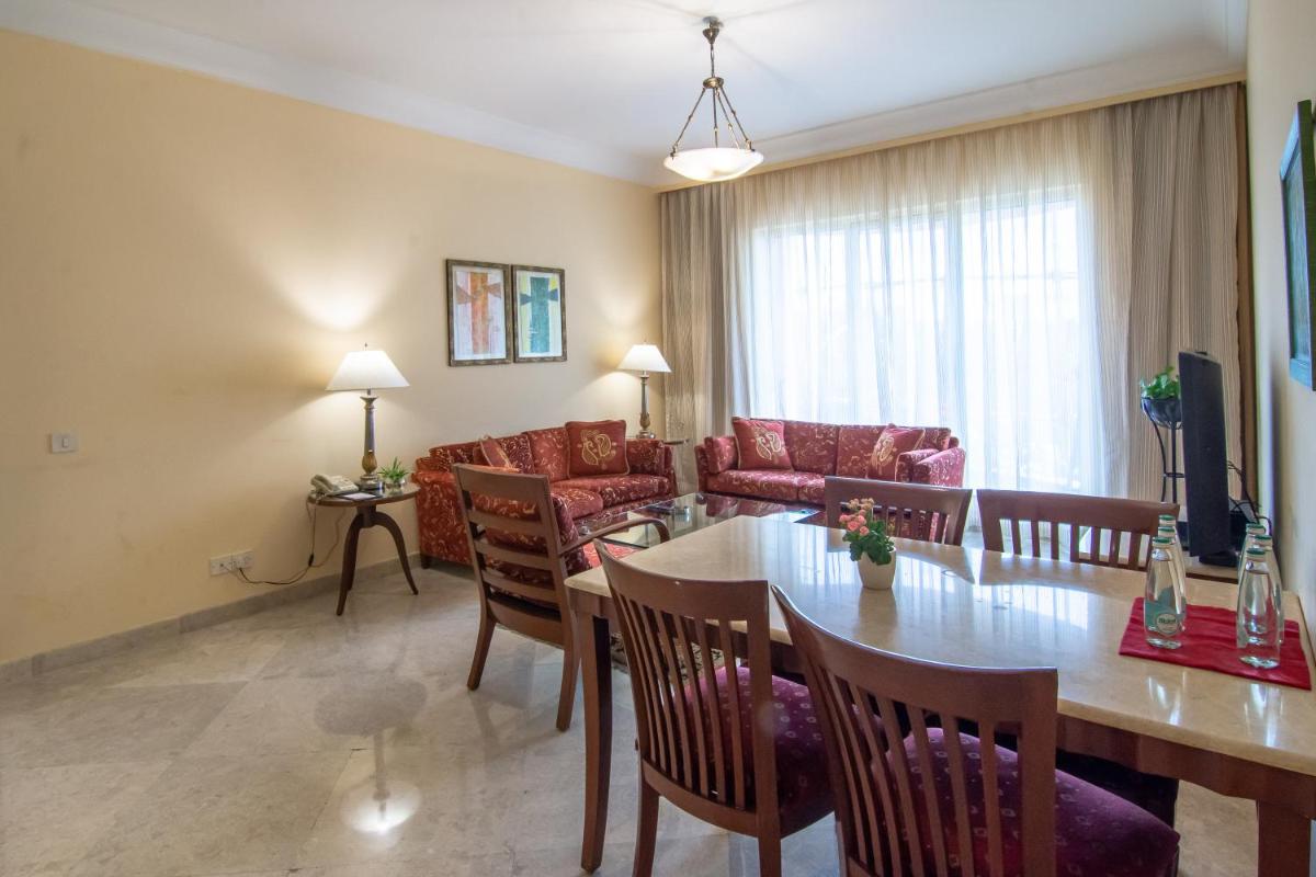 a dining room and living room with a table and chairs at The Lalit Mumbai in Mumbai