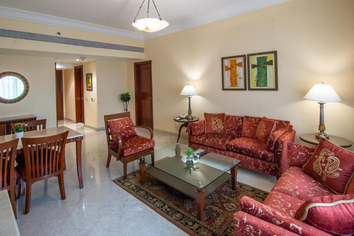 a living room with red couches and a table at The Lalit Mumbai in Mumbai