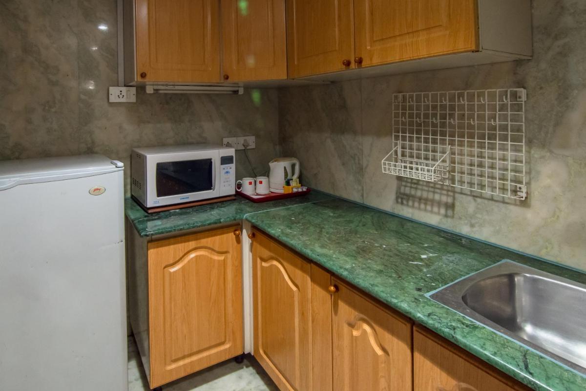 a kitchen with a sink and a microwave at The Lalit Mumbai in Mumbai
