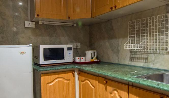 a kitchen with a white microwave and a sink at The Lalit Mumbai in Mumbai