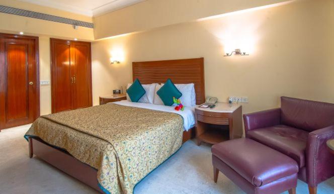 a hotel room with a bed and a desk and a couch at The Lalit Mumbai in Mumbai