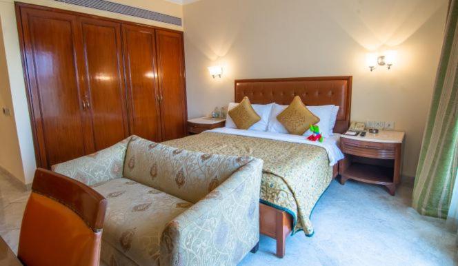 a hotel room with a bed and a couch at The Lalit Mumbai in Mumbai
