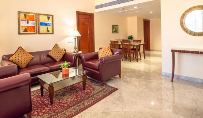 a living room with a couch and a table at The Lalit Mumbai in Mumbai