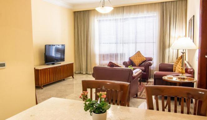 a living room with a couch and a television at The Lalit Mumbai in Mumbai
