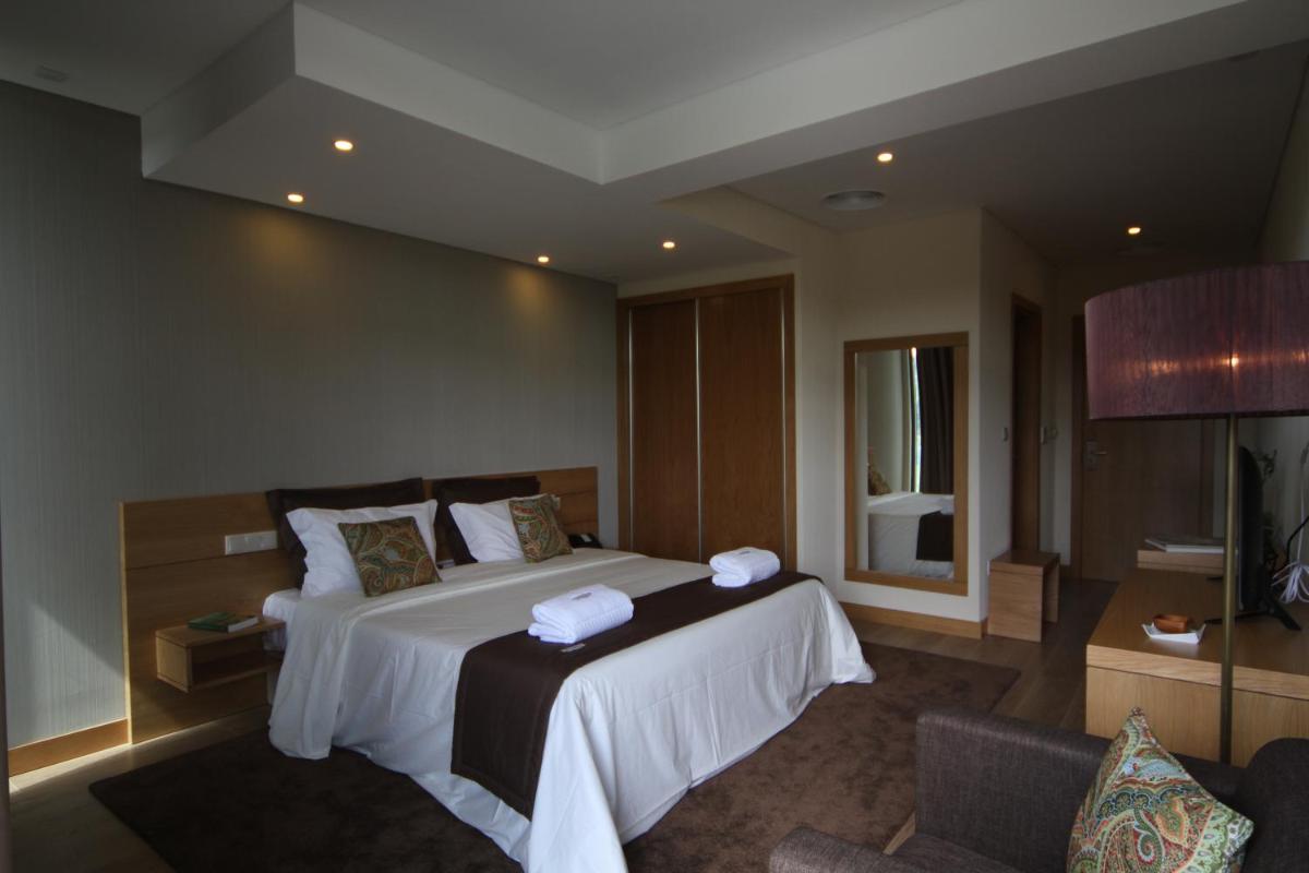 um quarto de hotel com uma cama com toalhas em Douro Cister Hotel Resort em Ucanha