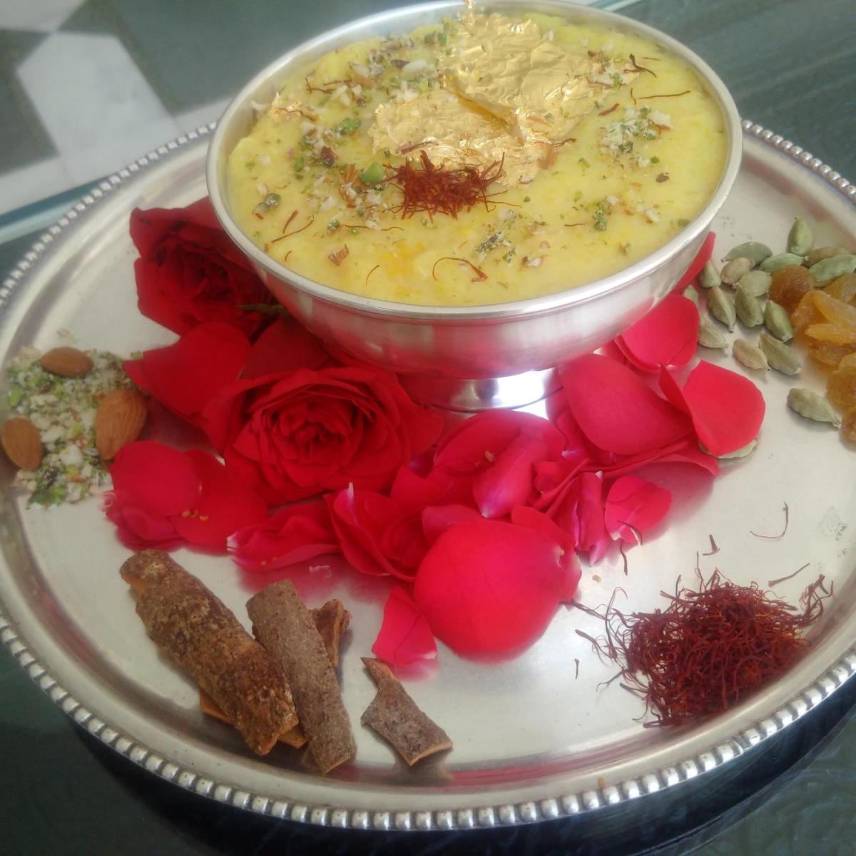 a plate of food with a bowl of soup and flowers at The Raj Palace (Small Luxury Hotels of the World) in Jaipur