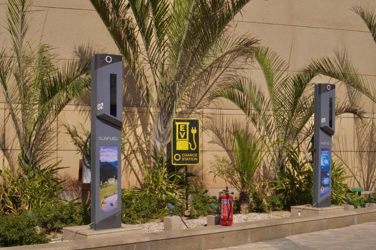 a parking sign in front of a building with palm trees at Radisson RED Chandigarh Mohali in Chandīgarh