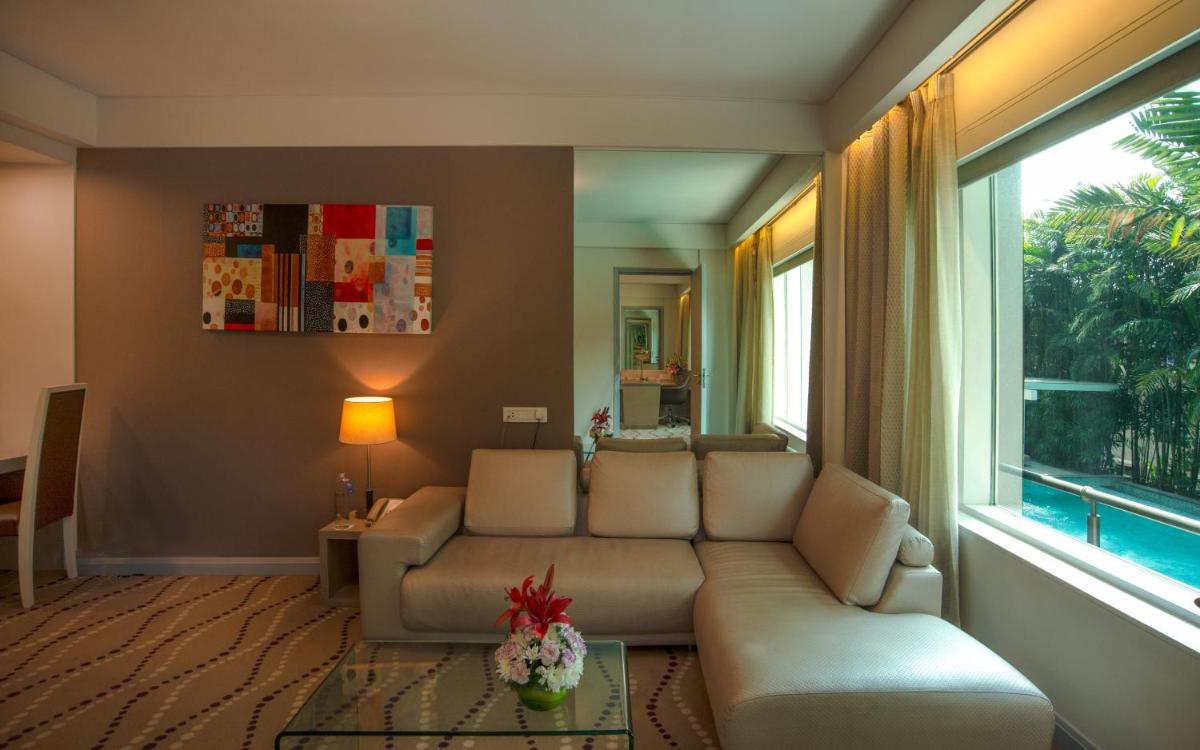a living room with a couch and a large window at Radisson Blu Bengaluru Outer Ring Road in Bengaluru