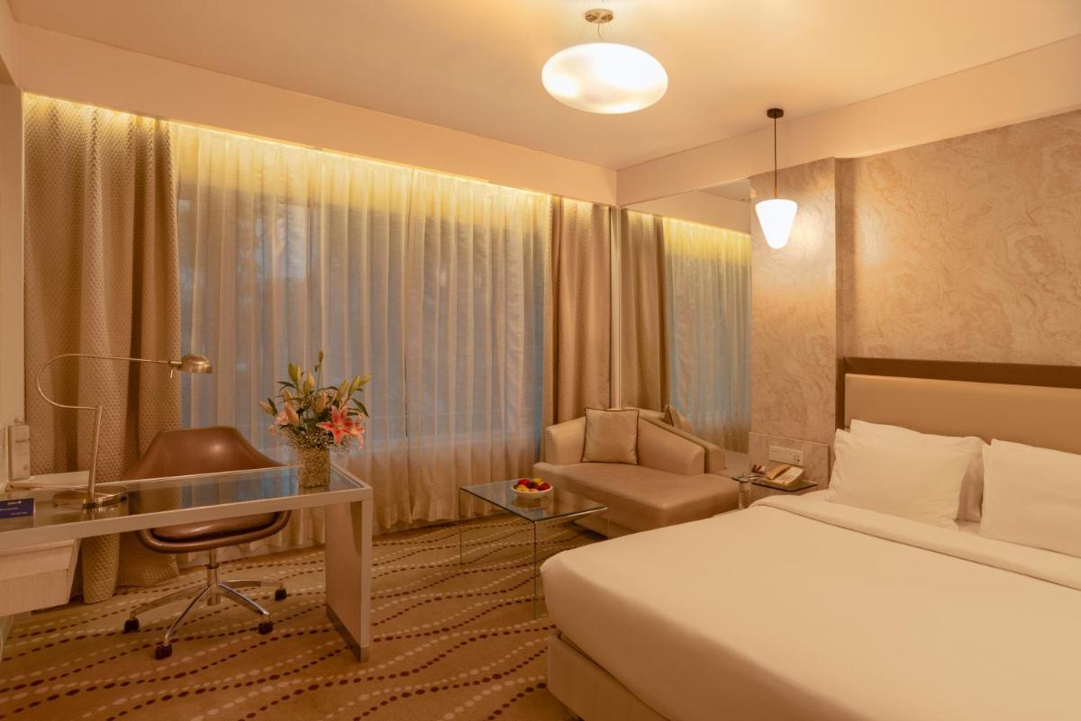 a hotel room with a bed and a desk at Radisson Blu Bengaluru Outer Ring Road in Bengaluru