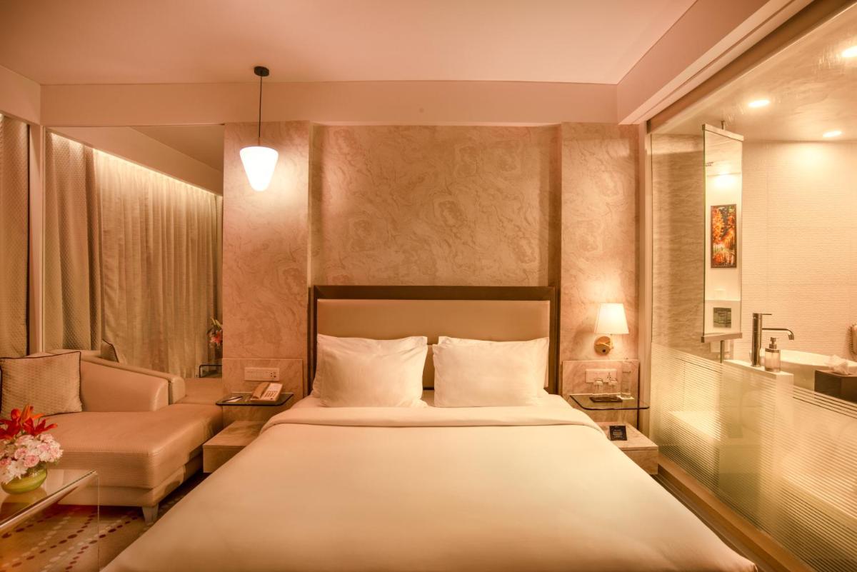 a hotel room with a bed and a couch and a bed sidx sidx at Radisson Blu Bengaluru Outer Ring Road in Bengaluru