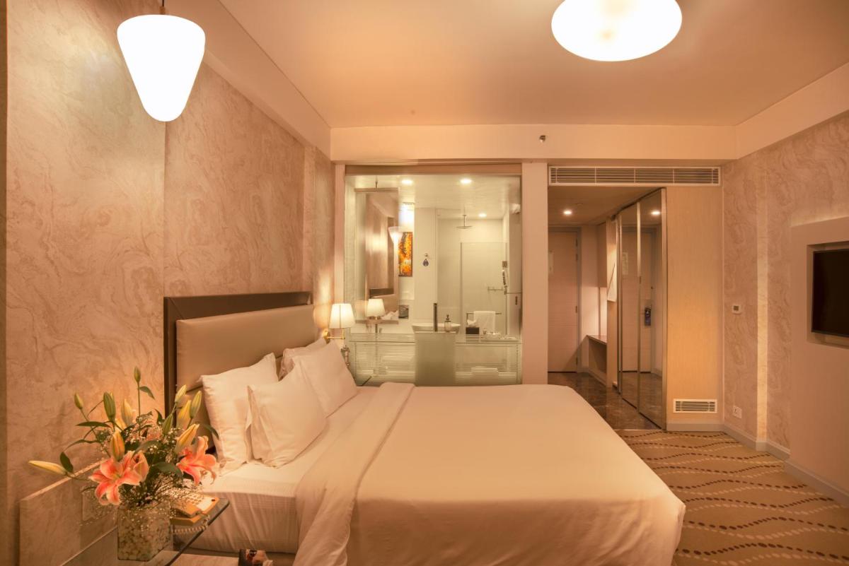 a hotel room with a bed and a bathroom at Radisson Blu Bengaluru Outer Ring Road in Bengaluru