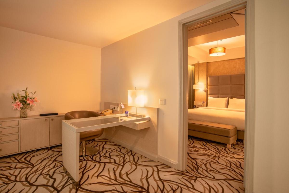 a hotel room with a sink and a bed at Radisson Blu Bengaluru Outer Ring Road in Bengaluru