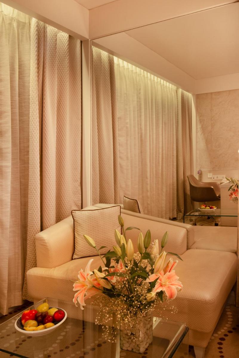 a living room with a couch and a table with flowers at Radisson Blu Bengaluru Outer Ring Road in Bengaluru