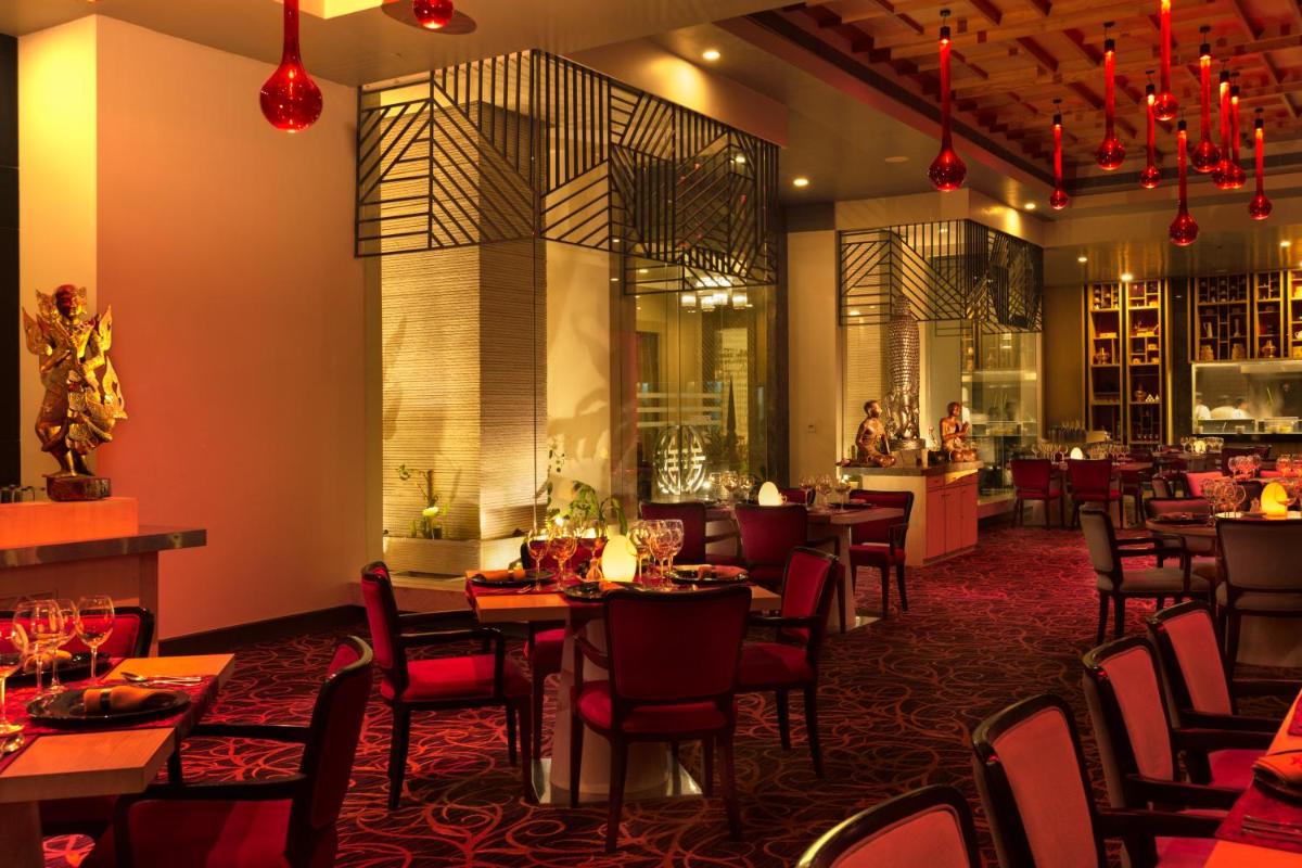 a restaurant with tables and chairs and a bar at Radisson Blu Bengaluru Outer Ring Road in Bengaluru