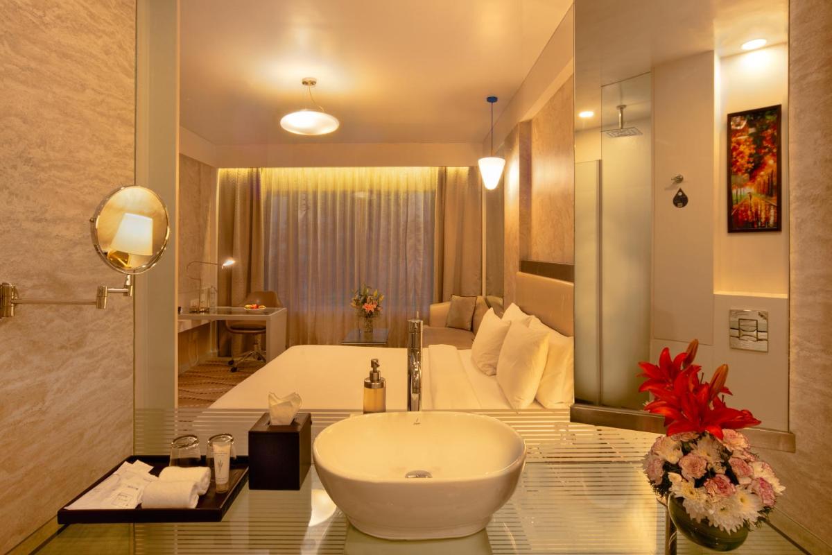 a bathroom with a large white tub and a sink at Radisson Blu Bengaluru Outer Ring Road in Bengaluru
