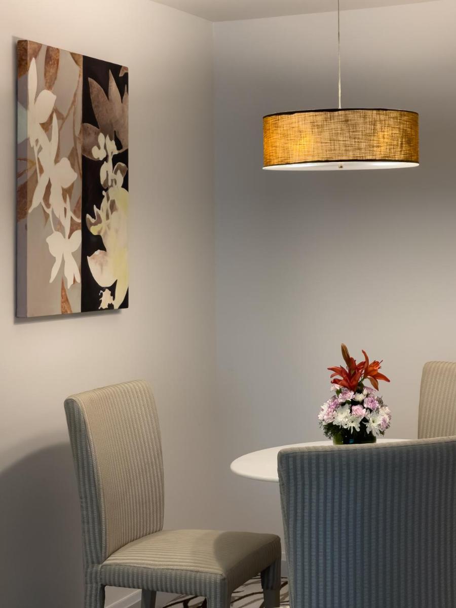 a dining room with chairs and a table and a lamp at Radisson Blu Bengaluru Outer Ring Road in Bengaluru