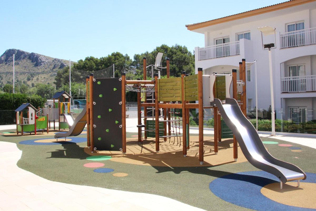 un parque infantil frente a un edificio en Mar Hotels Playa Mar & Spa, en Puerto Pollensa