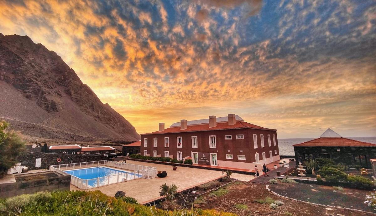 un edificio con piscina junto a una montaña en Balneario Pozo de la Salud, en Sabinosa