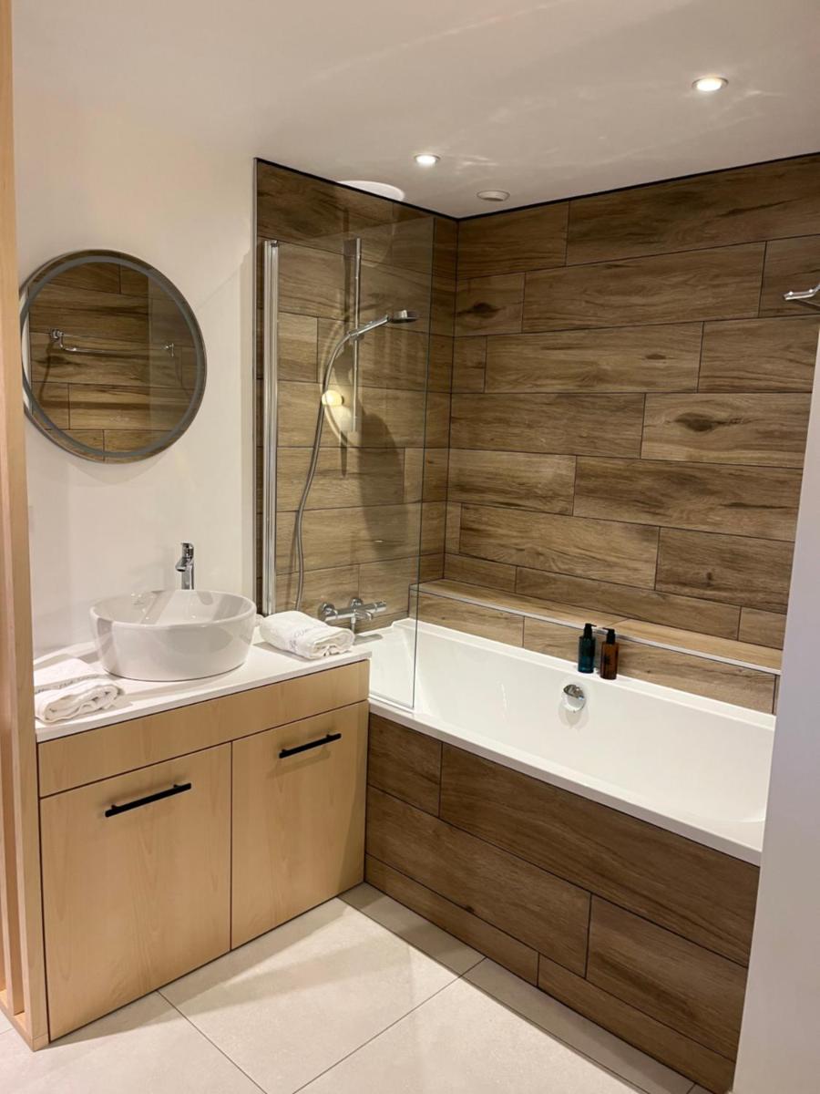 une salle de bain avec une baignoire, un lavabo et une douche dans l'établissement La Villa Bel Ange Hotel, à Saint-Philibert