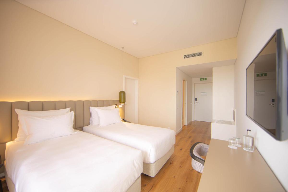 Uma cama ou camas num quarto em Sines Sea View Business & Leisure Hotel