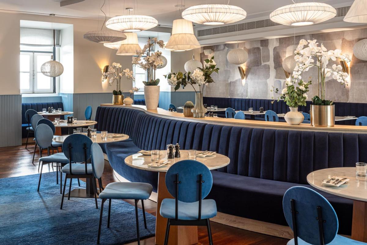 um restaurante com mesas e cadeiras e um bar em The Vintage Hotel & Spa Lisbon em Lisboa