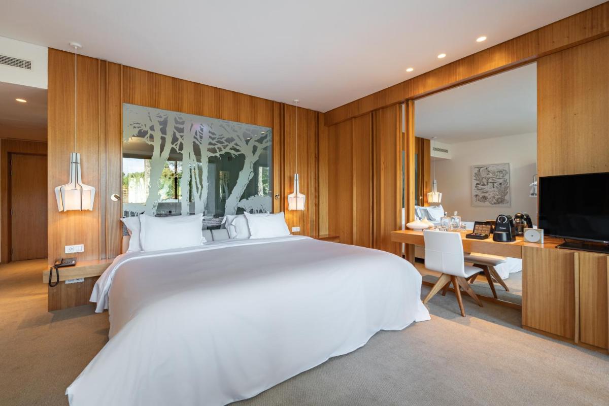 um quarto com uma grande cama branca e uma escrivaninha em Onyria Marinha Cascais, Vignette Collection by IHG em Cascais
