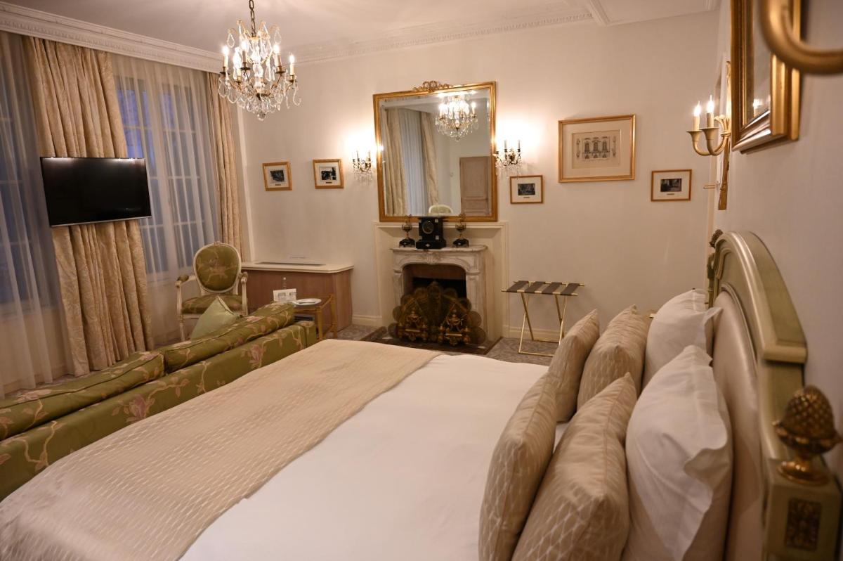 - une chambre avec un grand lit et une cheminée dans l'établissement Hôtel La Villa Eugene, à Épernay