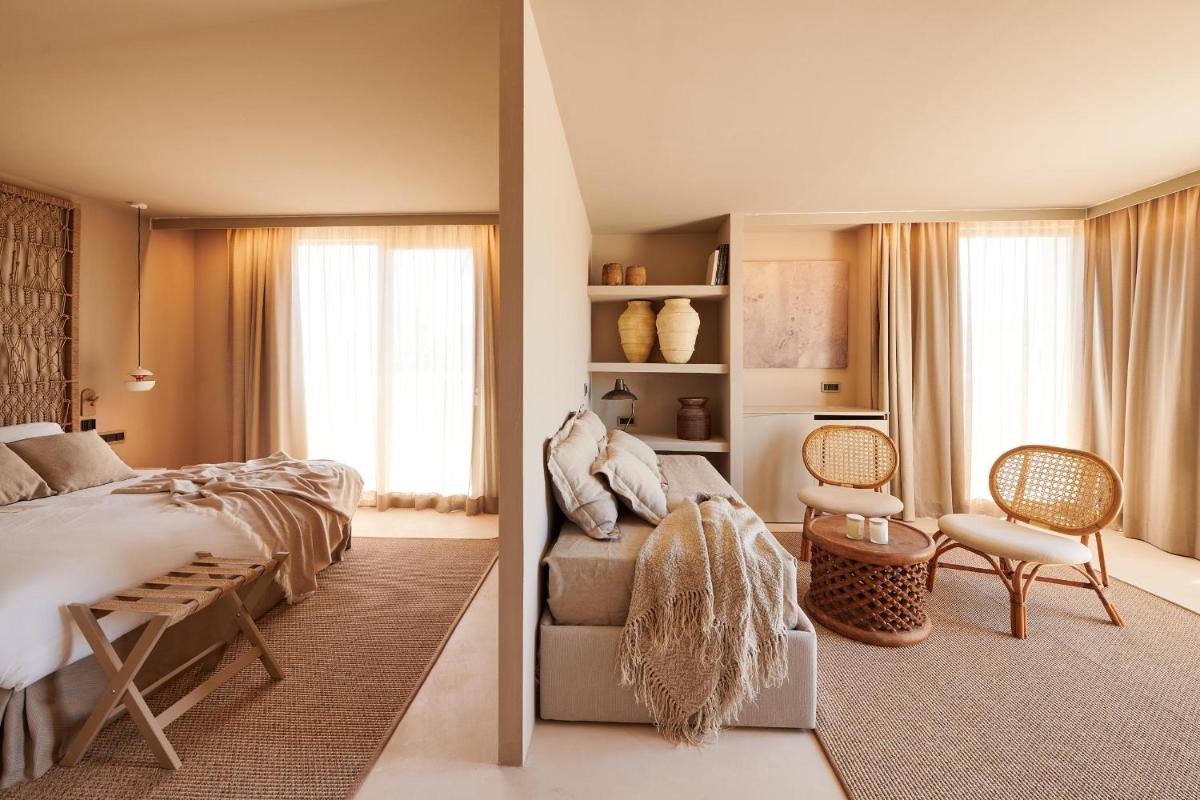 un dormitorio con una cama y una silla en Barefoot Hotel Mallorca, en Portocolom
