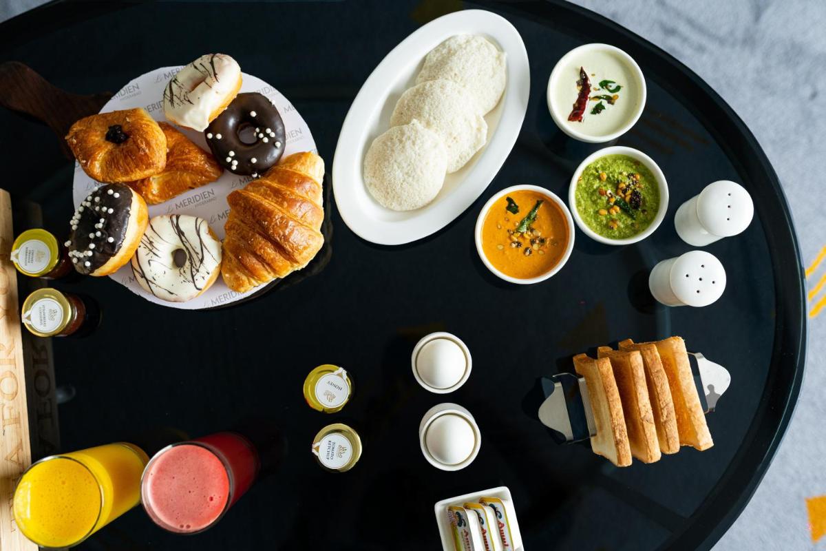 a black plate of food with different types of pastries at Le Meridien Hyderabad in Hyderabad