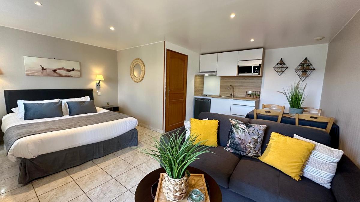 une chambre avec un lit et un canapé dans une pièce dans l'établissement La Maison Blanche, à Sangatte