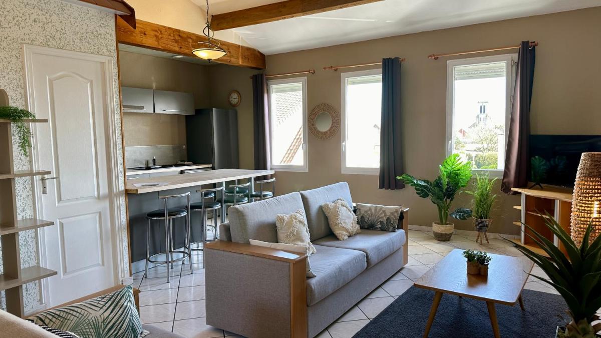 un salon avec un canapé et une cuisine dans l'établissement La Maison Blanche, à Sangatte