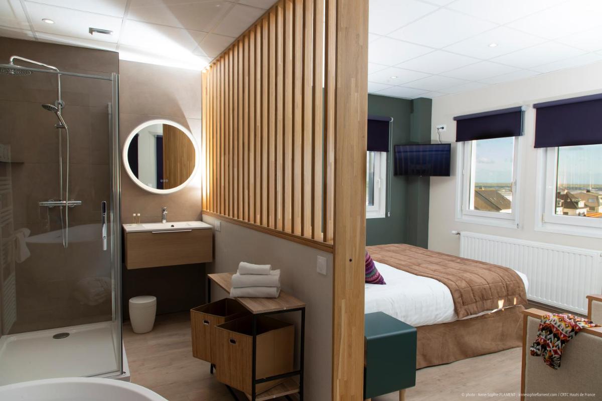 une salle de bain avec un lit, une douche et un lavabo dans l'établissement La Maison Blanche, à Sangatte