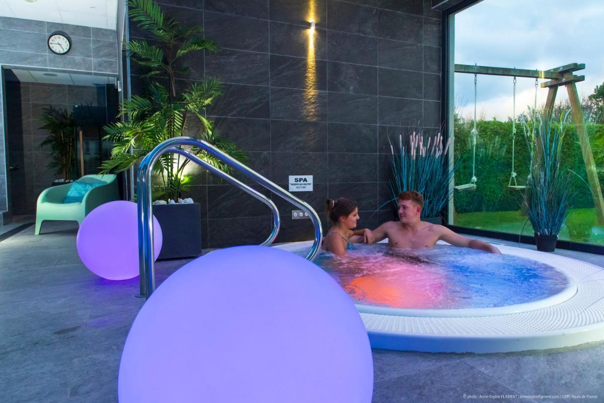un homme et une femme dans un bain à remous dans l'établissement La Maison Blanche, à Sangatte