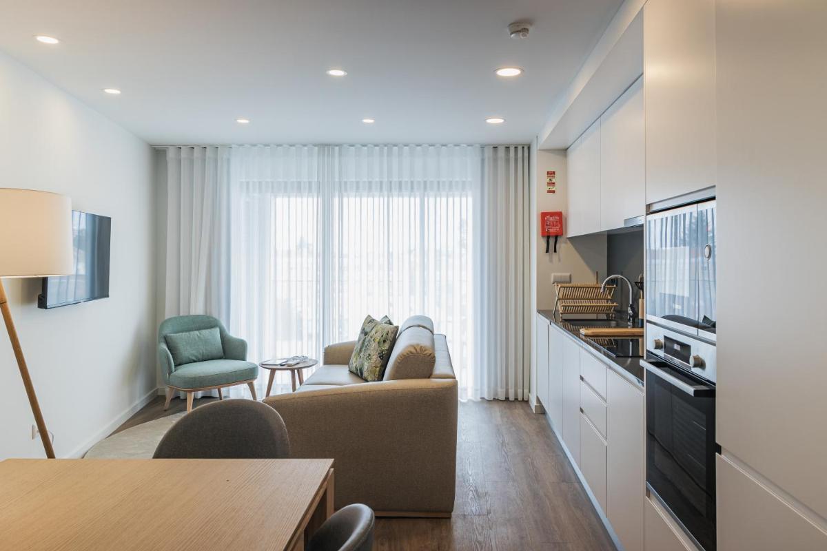 uma sala de estar com um sofá e uma cozinha em Alto do Forte em Ponta Delgada